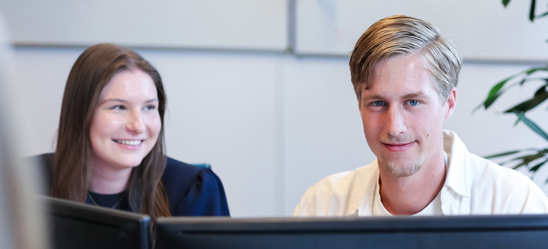 Dennis en Claire, campus recruiters bij Ballast Nedam, poseren samen op kantoor