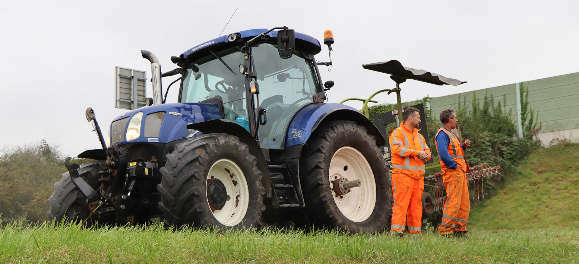 Mark den Hertog staat samen met collega voor machine om de bermen langs snelwegen te maaien