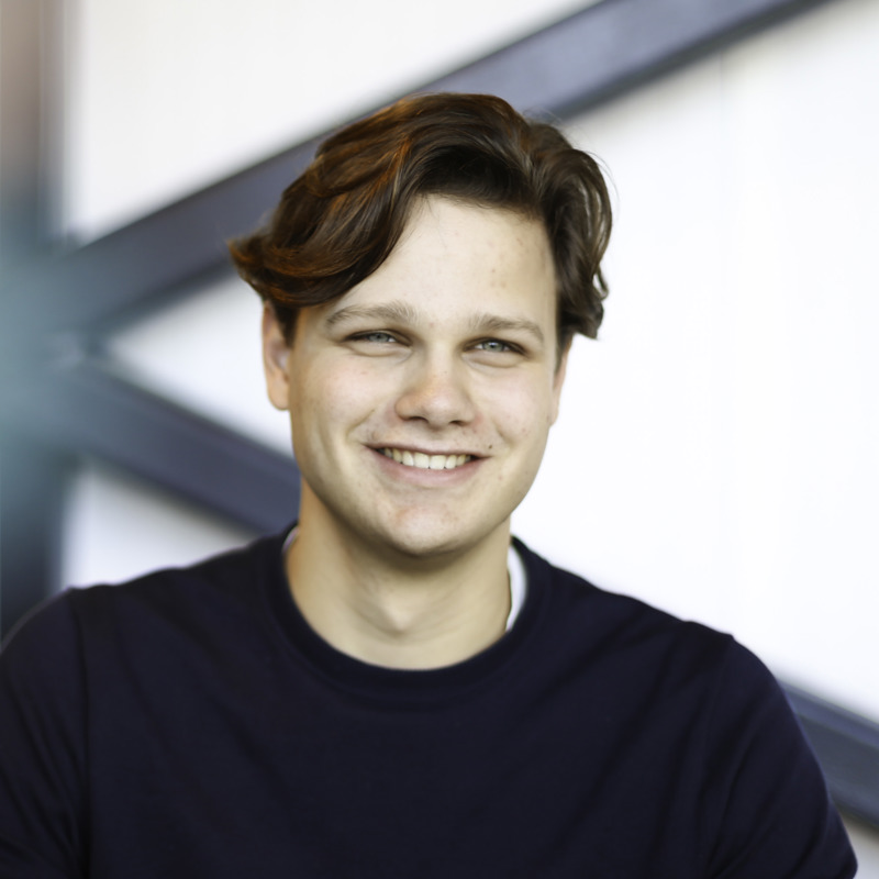 Willem Veldhuizen, stagiair bij Ballast Nedam Digitalisering en Innovatie, glimlachend in zijn kantoor in Nieuwegein