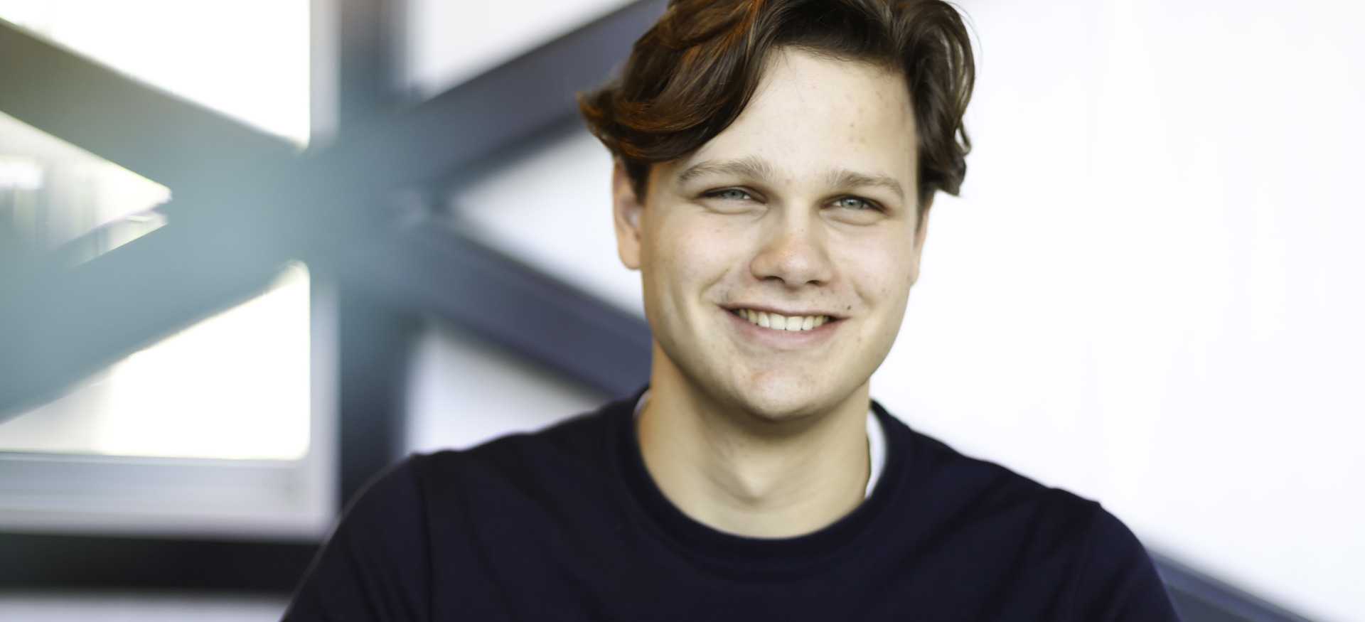 Willem Veldhuizen, stagiair bij Ballast Nedam Digitalisering en Innovatie, glimlachend in zijn kantoor in Nieuwegein