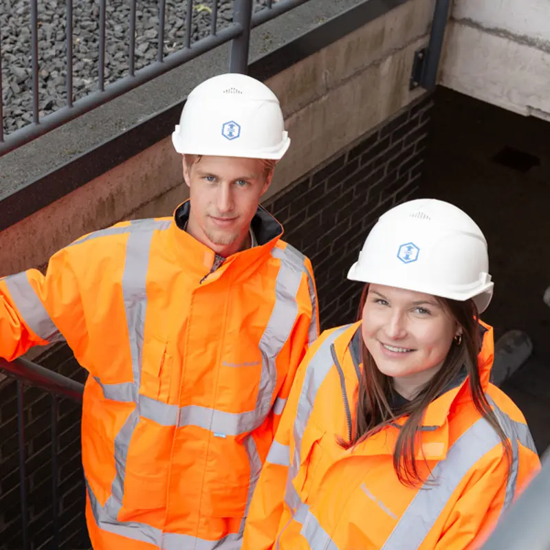 Dennis van den Hazel en Claire de Groot, campus recruiters bij Ballast Nedam, poseren samen bij een infra project